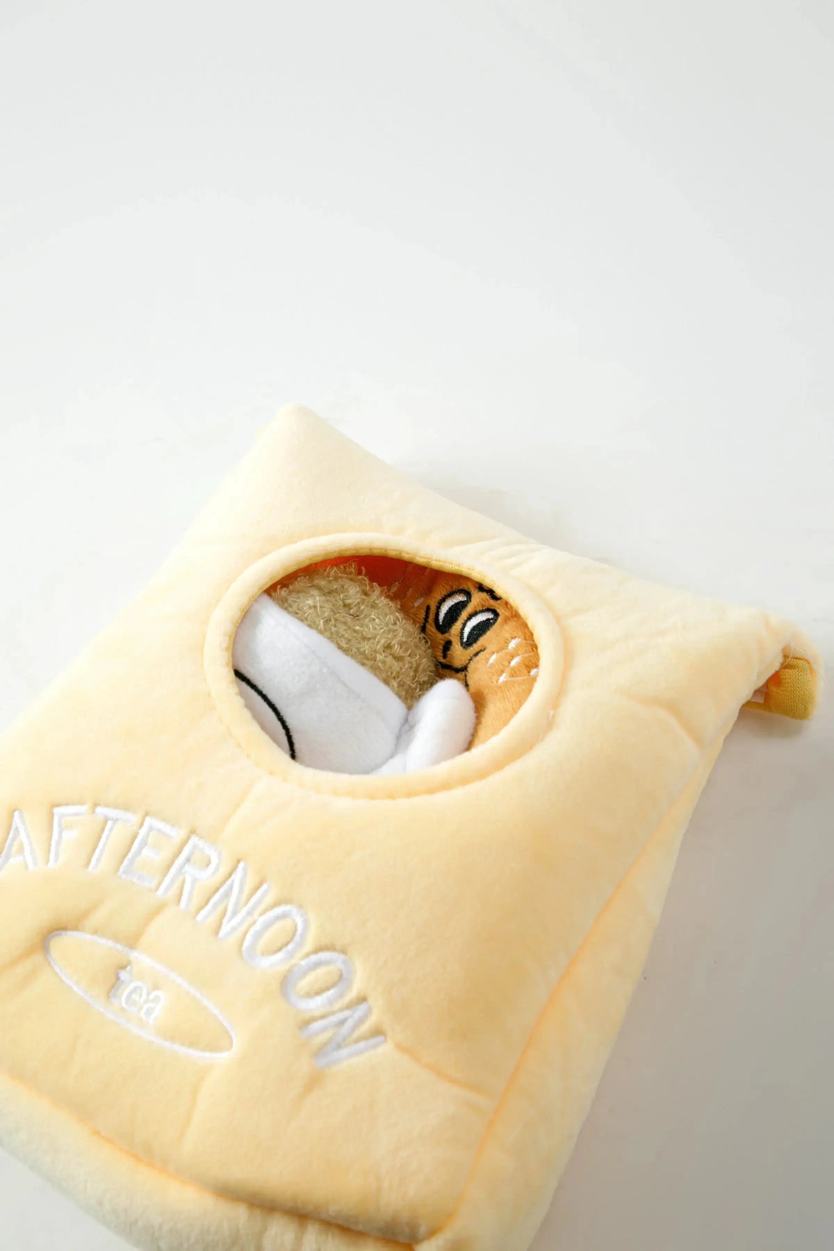 Close-up of the Afternoon Tea plush hide-and-seek pouch filled with plush toys