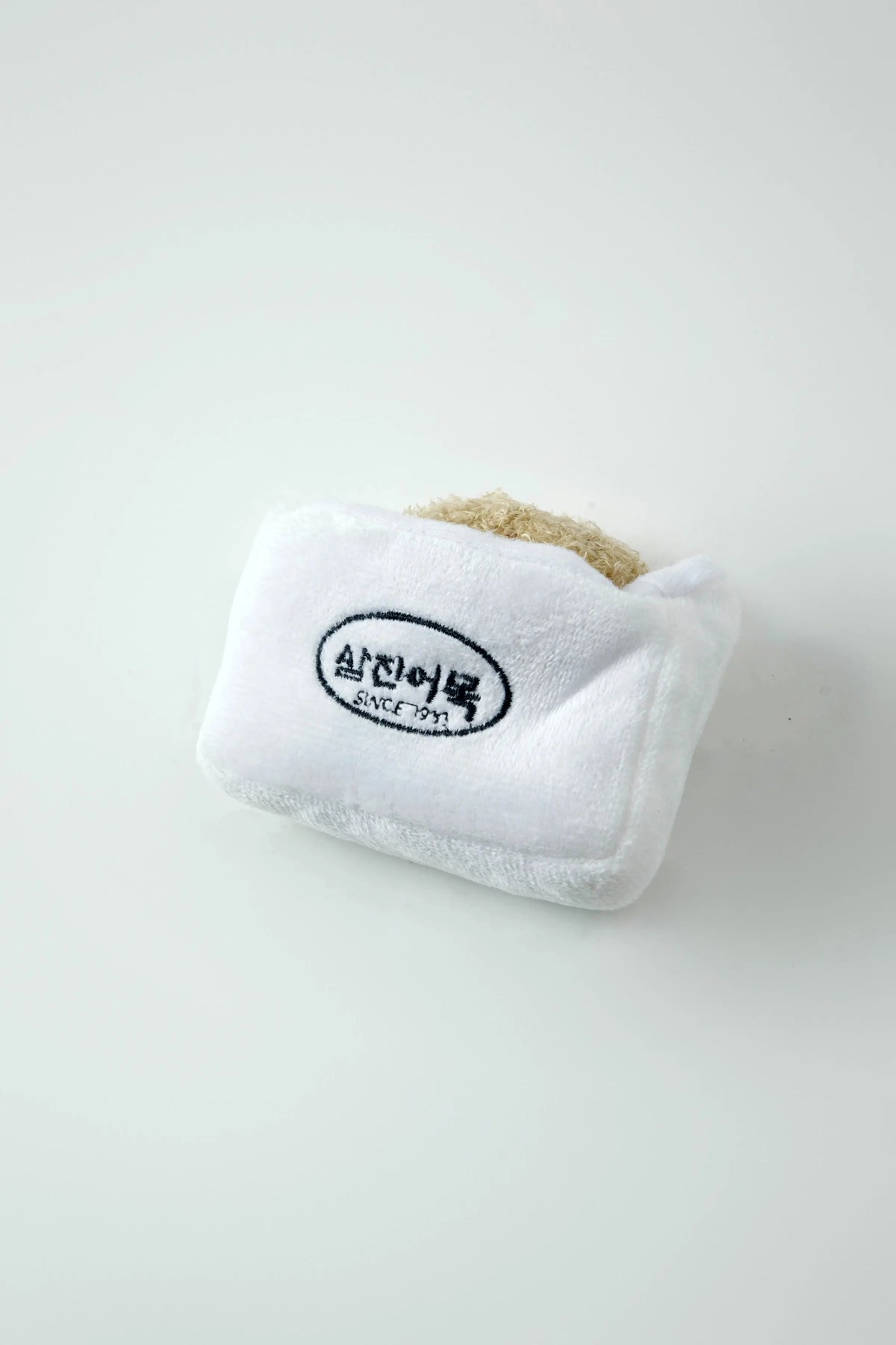 Close-up of the Afternoon Tea white plush pouch with a hidden toy