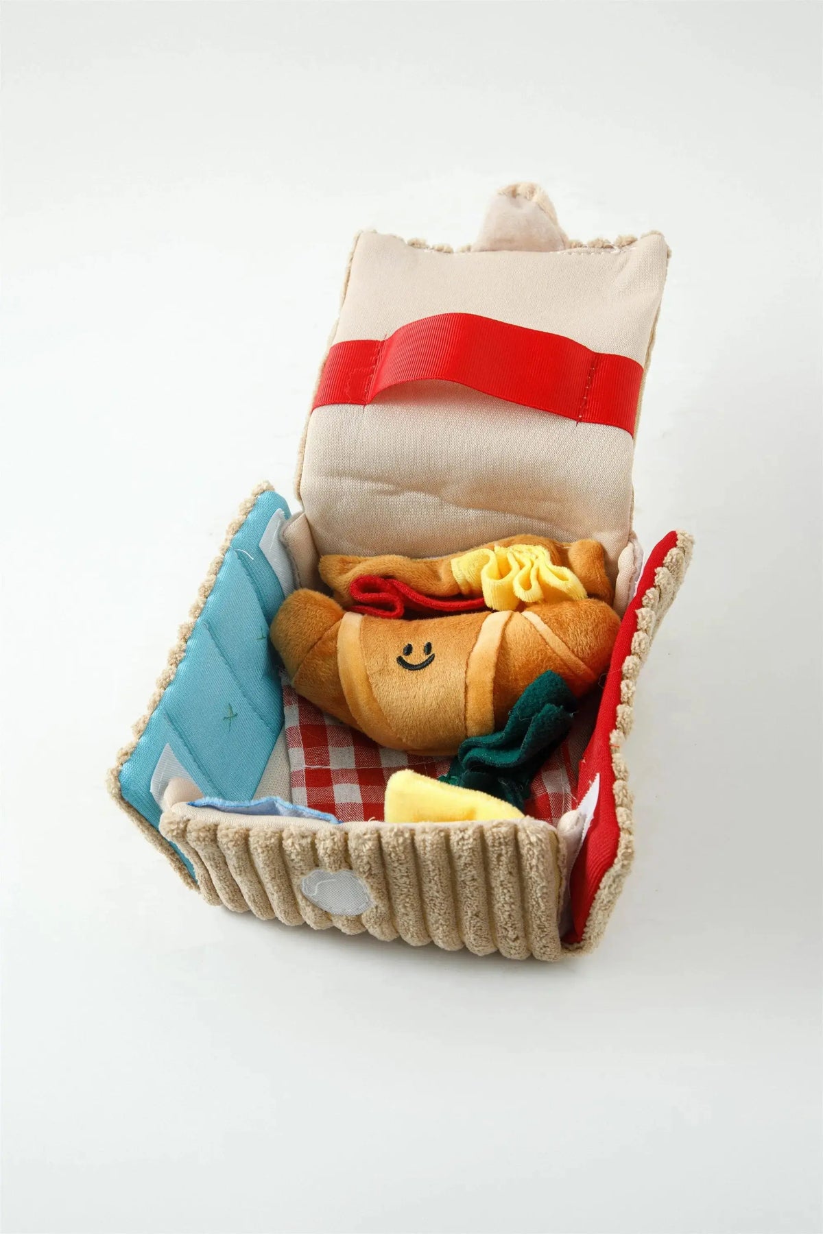 Close-up of the Picnic Paws snuffle mat with its plush croissant toy